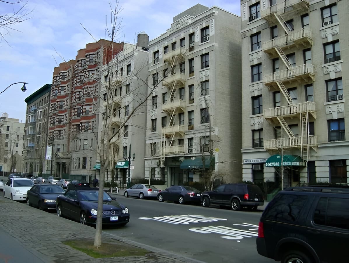 A street with many cars parked on the side of it.